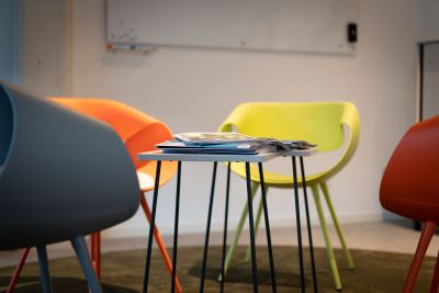 Empfangslösung mit bunten Armlehnstühlen und Beistelltisch