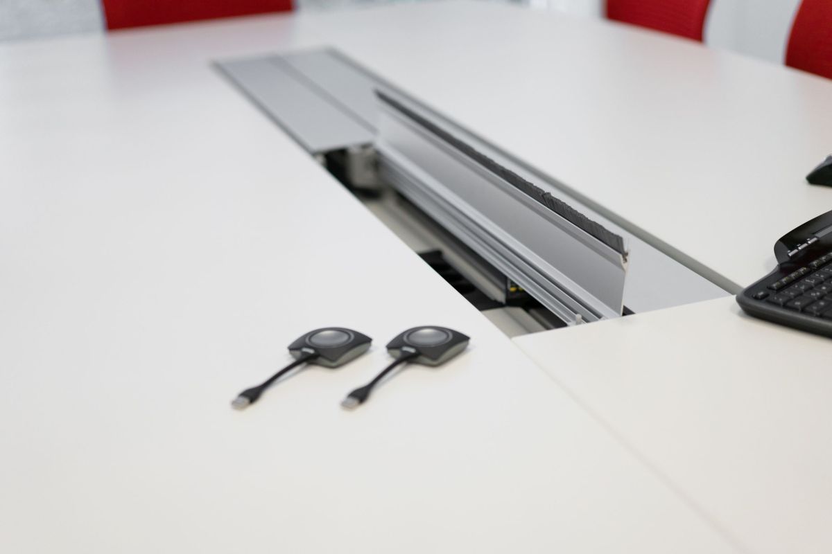 Konferenztisch mit Strom- und Datenanschlüsse bündig unter Kabelklappen eingearbeitet